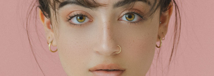 Brown eyed girl with gold piercings
